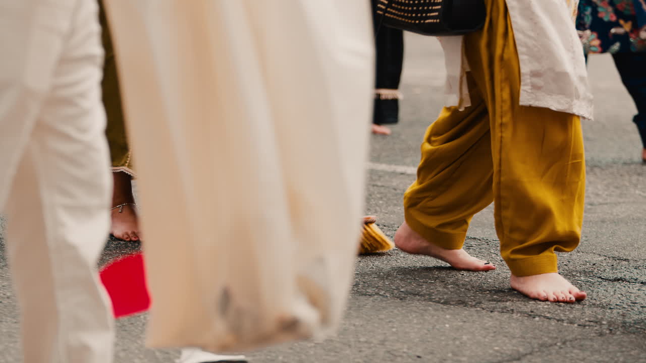 Donne indiane camminano a piedi nudi durante la festa religiosa Vaisakhi