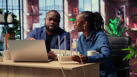 african american couple at home office troubleshooting their wi fi modem