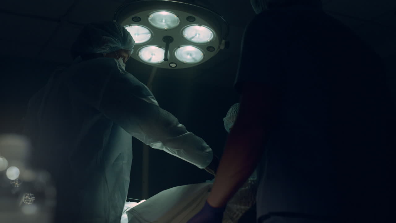 Professional surgeon stitch incision in operating room. Intensive care unit team