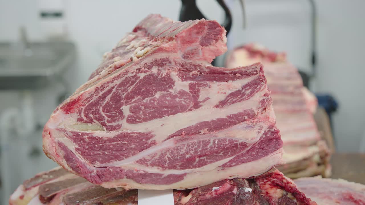 A butcher scraping a slab of meat with a knife