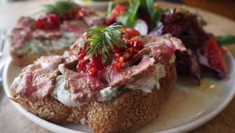gourmet open-faced sandwich with sliced beef and fresh dill