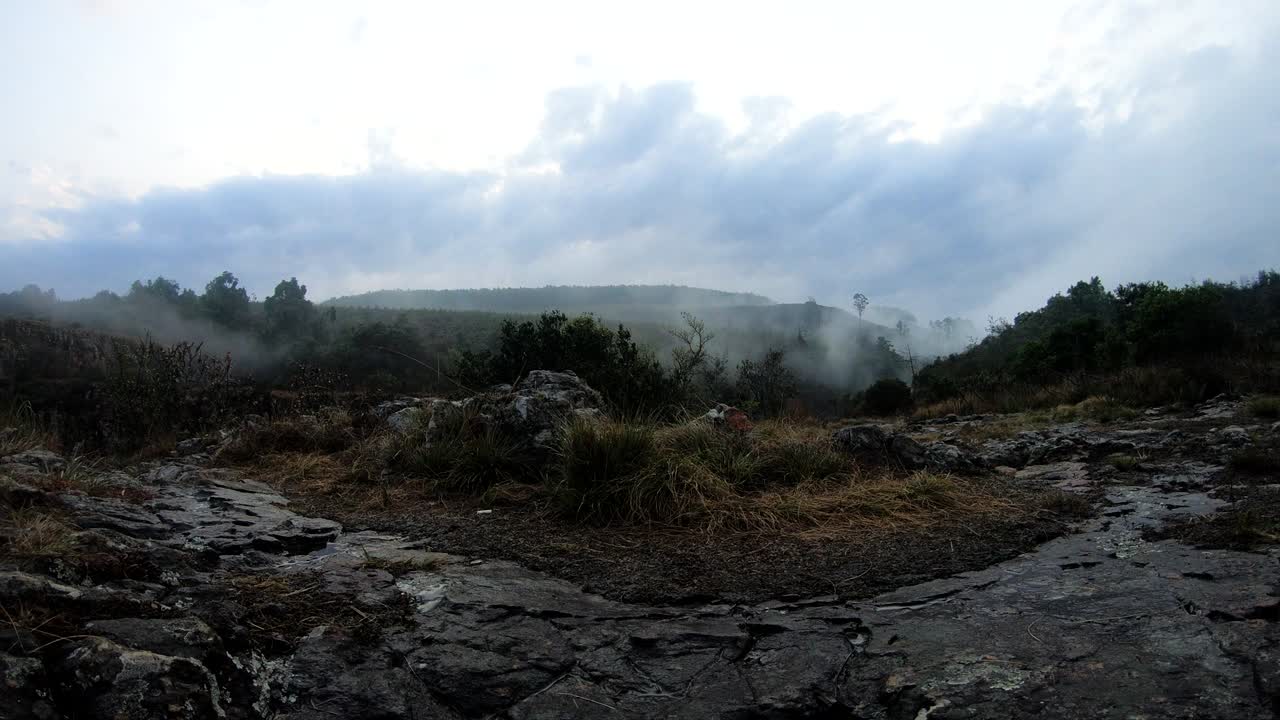 Time lapse shot of mist from low hanging clouds pushing up and over a hillside rock face on a cold wet winter’s day, South Africa