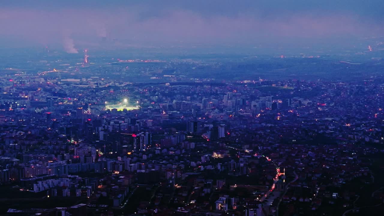 Evening haze blankets Pristina cityscape in sweeping cinematic twilight motion