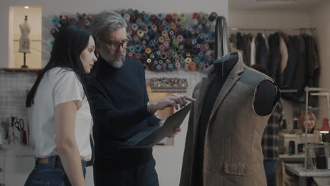 fashion designers discussing a design on a laptop