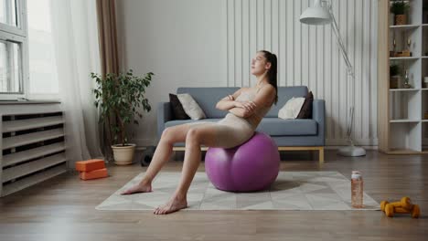 woman exercising with a yoga ball at home