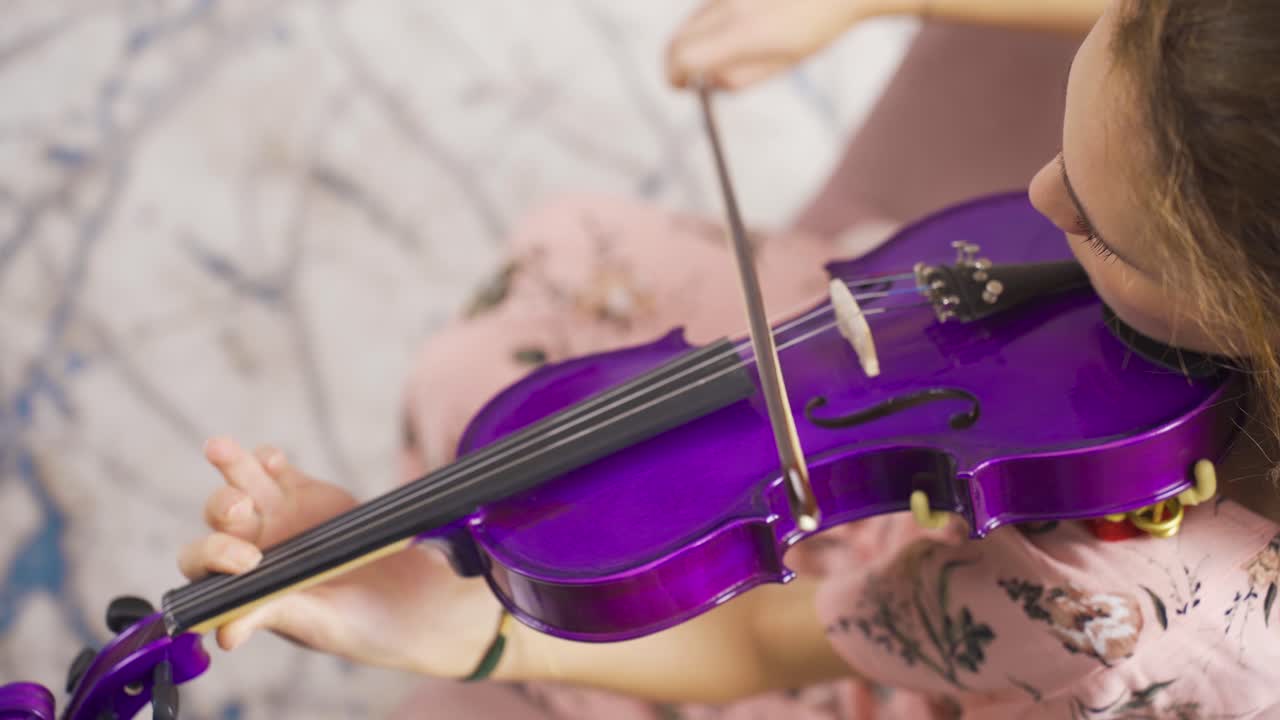 primer plano de una mujer músico tocando el violín en casa, componiendo, tocando música.