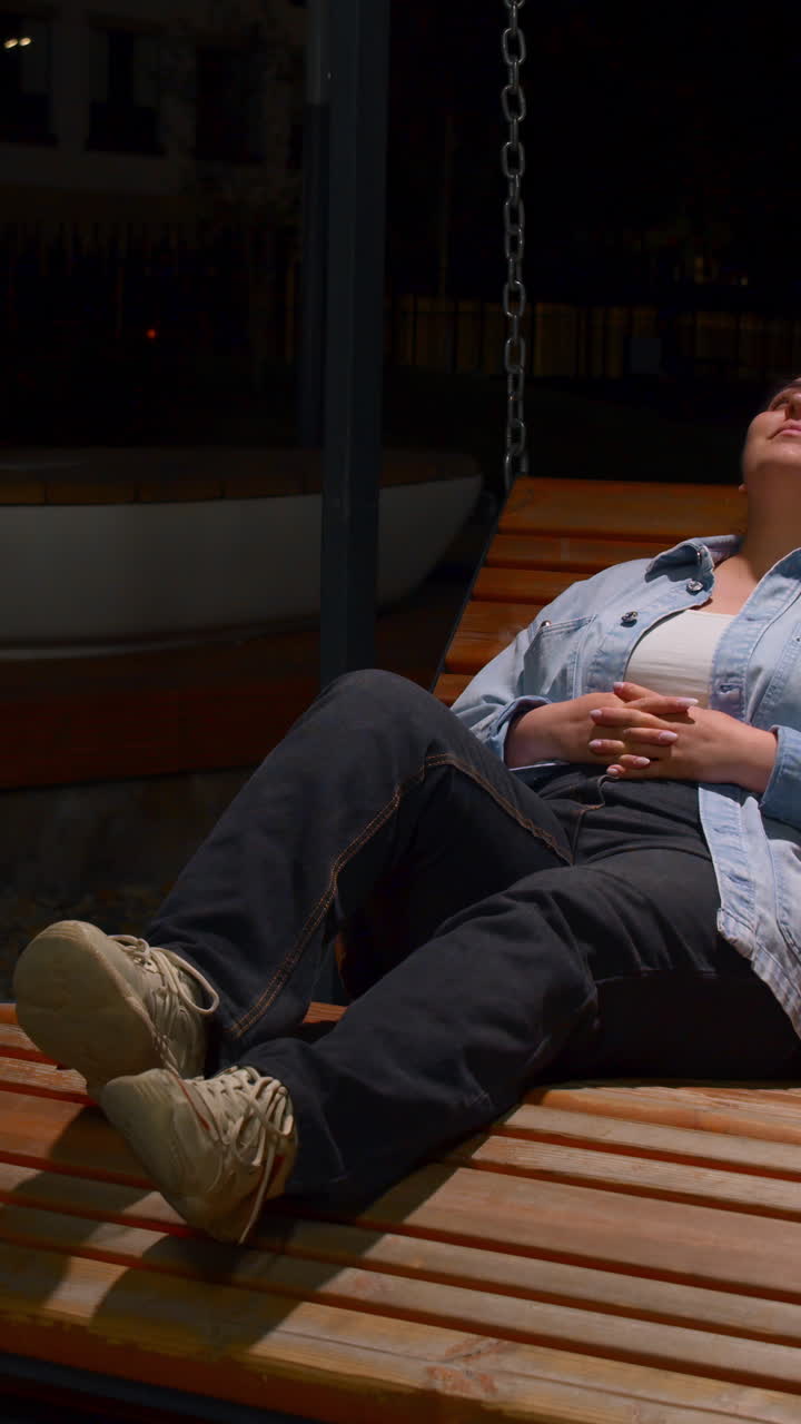 밤 에 공원 벤치 에 앉아 있는 여자