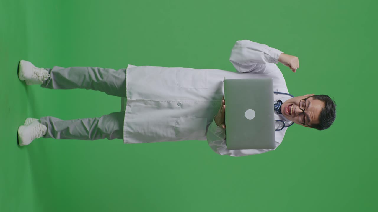 médico emocionado celebrando el éxito con la computadora portátil