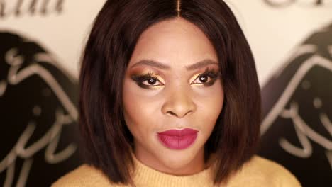 beauty portrait of a smiling woman with gold eyeshadow and red lipstick