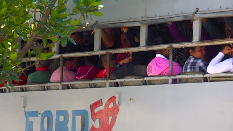 zoom out from a crowded bus carrying workers to reveal the town of cienfuegos cuba