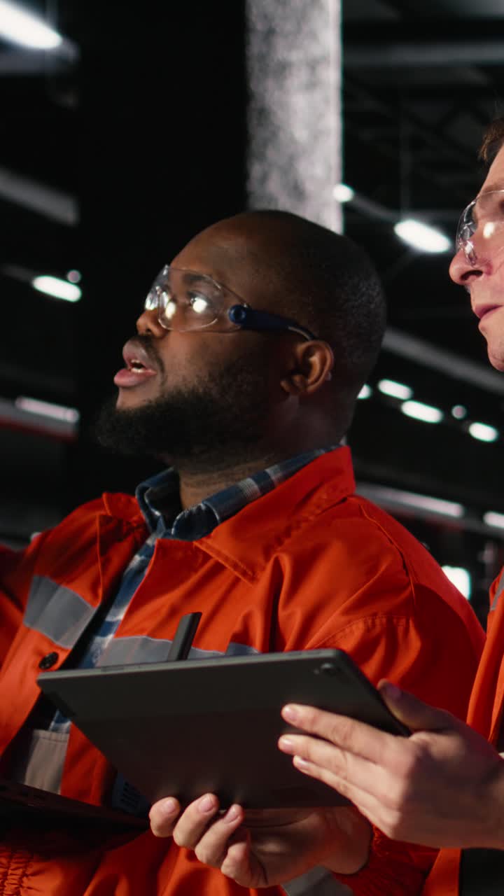 Vertical Video Employees team guide assembly and fabrication duties in a warehouse facility