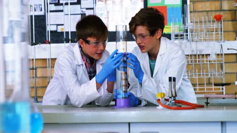 niños de escuela haciendo experimentos químicos en el laboratorio de la escuela