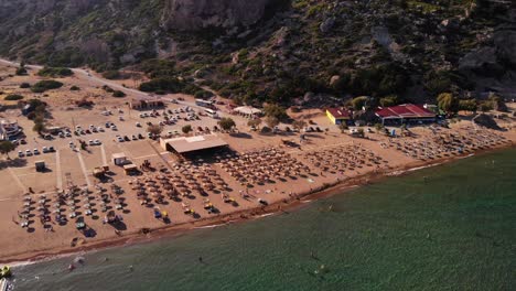 Luftaufnahme-Des-Breiten,-Unberührten-Tsambika-Strandes-Mit-Liegestühlen-Und-Sonnenschirmen-Auf-Der-Insel-Rhodos-In-Griechenland