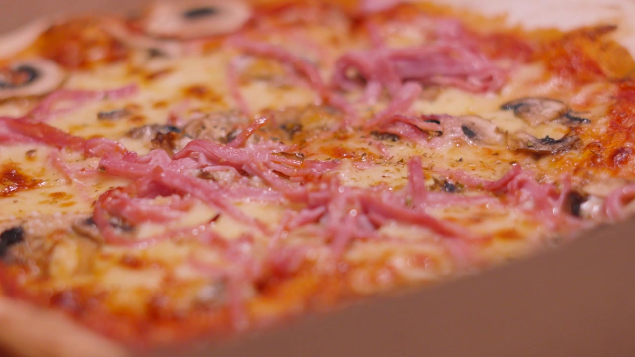 Ripresa lenta della telecamera su pizza prosciutto e funghi con gustosa mozzarella su crosta sottile