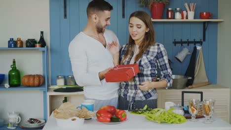 couple exchanging a gift in a kitchen