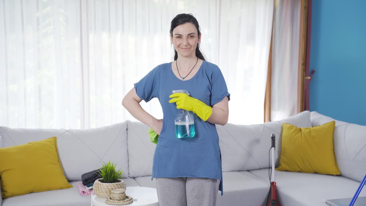 mirando a la cámara con suministros de limpieza.