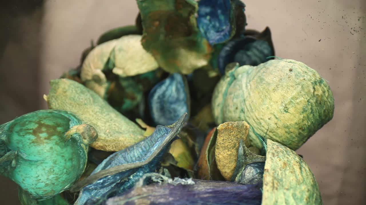 empujando lentamente profundamente en un jarrón de popurrí azul y verde