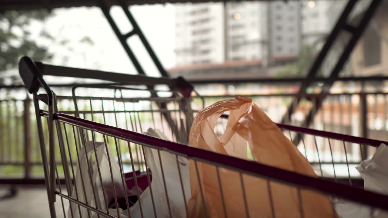 시장 센터 야외에서 악천후와 함께 쇼핑 카트에 바람이 부는 비닐 봉지