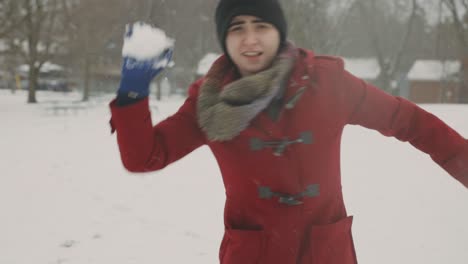 Caucasian-Lady-Forming-Snowball-And-Throws-Directly-To-The-Camera---Handheld,-Tilt-Up-Shot