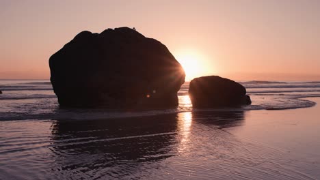 Silueta-De-Grandes-Rocas-Con-El-Sol-Rompiendo-Detrás-Al-Amanecer-Colorido