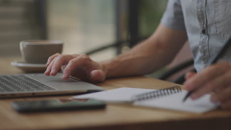 hombre de negocios con pluma escribiendo nuevas citas información en el concepto de organizador raza mixta manos masculinas haciendo notas en papel personal planificador en el escritorio aprender sobre el mercado de valores e inversiones