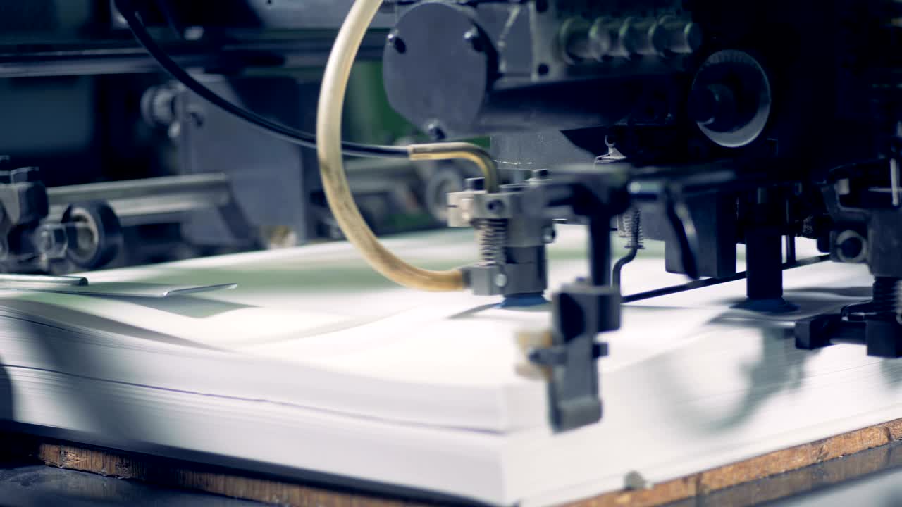 несколько листов бумаги вытесняются промышленной машиной на высокой скорости