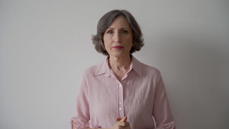 worried old woman looking at camera on white background