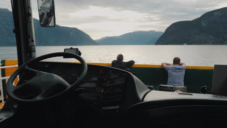 view from the bus that floats by ferry across the fjord two drivers are resting ahead