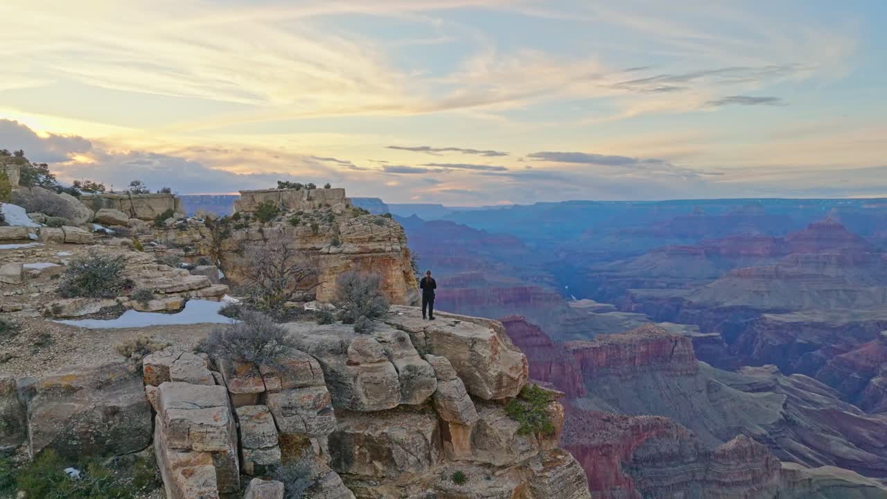 hombre aislado sobre acantilados de roca geológica en el parque nacional del gran cañón, arizona, estados unidos