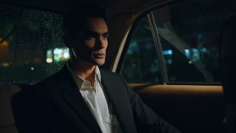 thoughtful passenger looking rainy window riding car closeup. business man auto