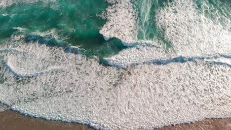vista de drones de hermosas imágenes interminables sin fisuras mientras las olas del mar turquesa rompen en la costa arenosa