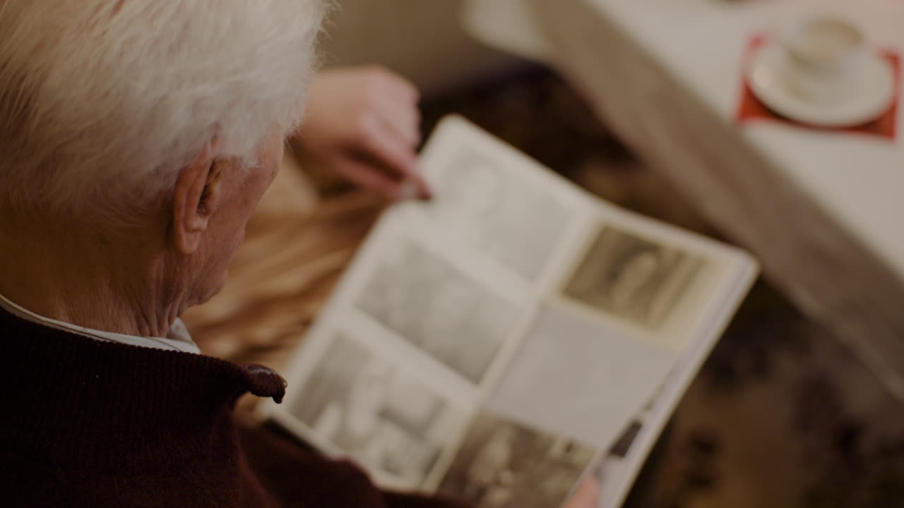 Senior Man Looking At Photo Album During Christmas