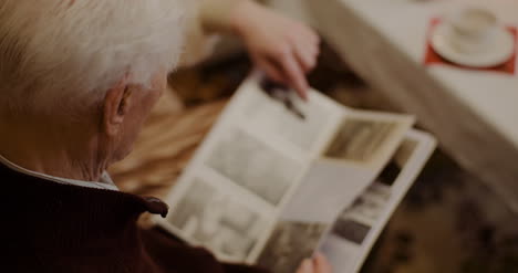 senior man looking at photo album during christmas