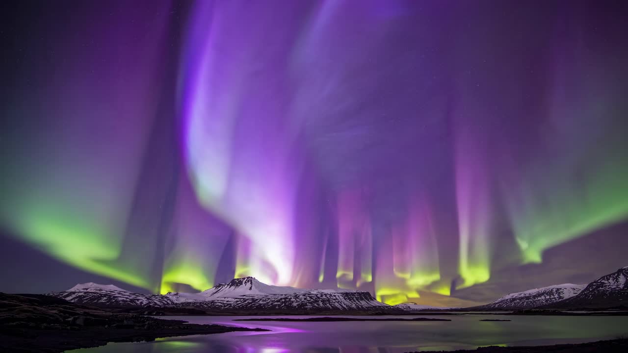 A mesmerizing wide-angle video capture of the Northern Lights over snow-capped mountains
