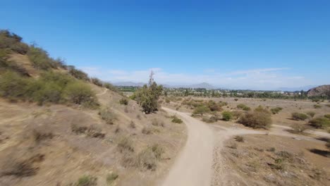 Cinematic-FPV-flight-over-dry-Chilean-landscape-and-vegetations-around-surrounded-by-mountains