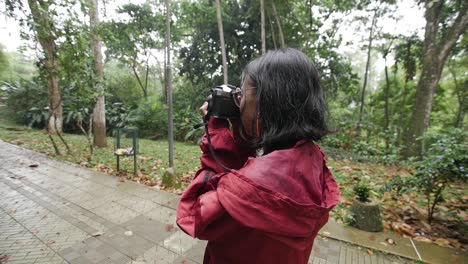 orbit-shot-of-a-girl-taking-photo-with-film-camera