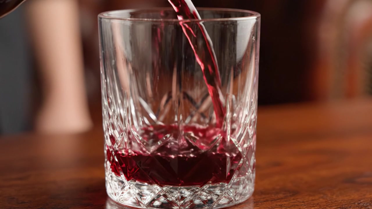 Un Versamento Sofisticato: Catturare l'arte di versare liquido in un bicchiere di cristallo, evidenziando il contrasto di colore e texture in ogni fotogramma.