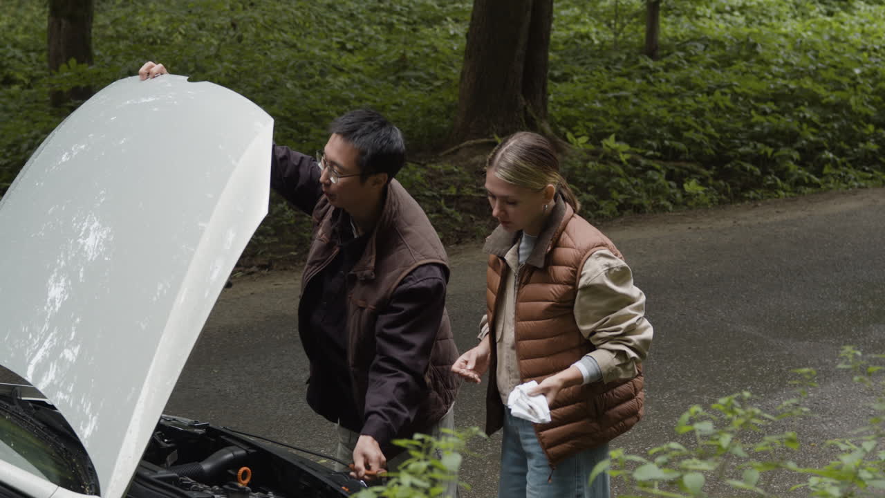 People looking at a car engine