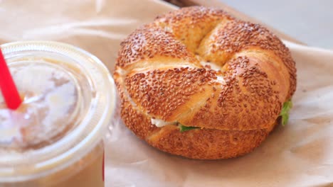 sándwich de bagel de semillas de sésamo con café helado