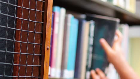 hand reaching for a book on shelf