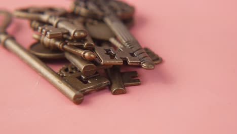 antique bronze keys on a pink background