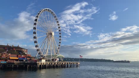 Beautiful-wide-shot-of-the-famous-Seattle-tourist-destination-ferris-wheel-on-pier-57-during-golden-hour-on-a-warm-sunny-summer-day-in-the-state-of-Washington-in-the-United-States-of-America