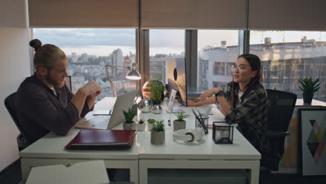 Two colleagues working late at agency closeup. Resting man communicating woman
