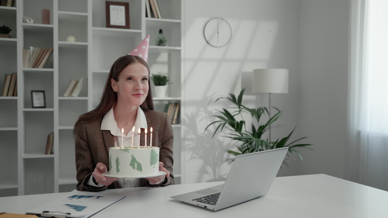 Woman celebrates birthday with cake in office