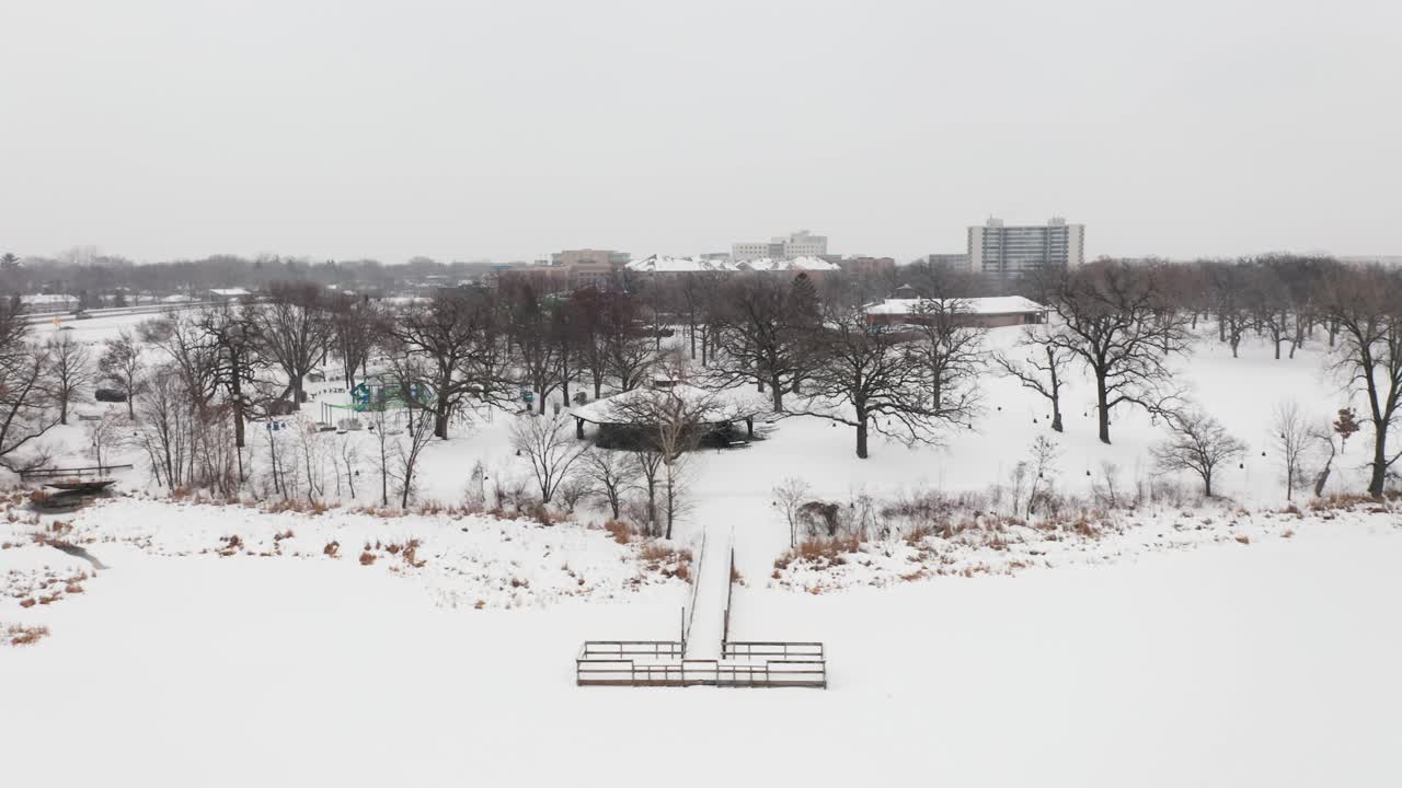 겨울 동안 얼어붙은 호수에 눈으로 덮인 공원의 공중 선착장