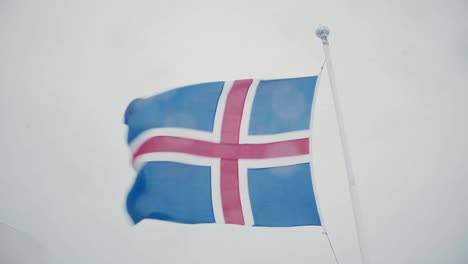 close-up view of icelandic flag on flagpole on the board of the ship. flag waving on the wind