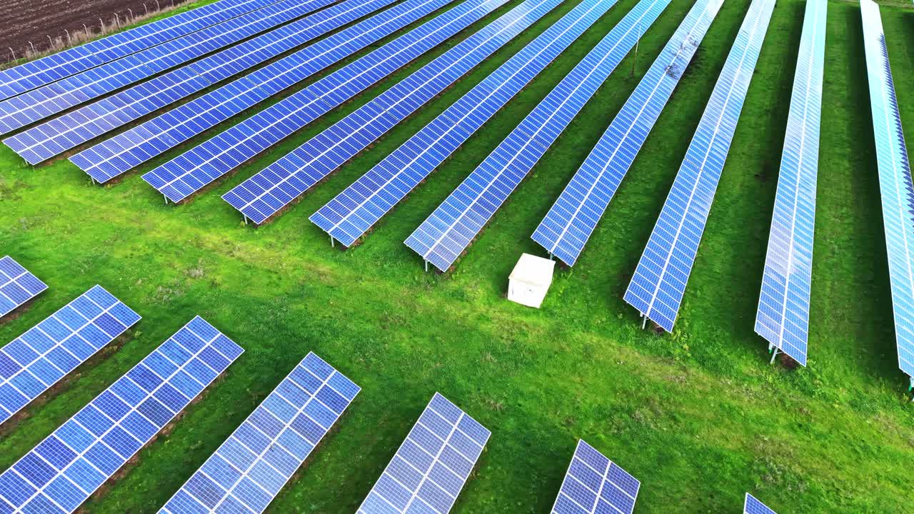 Aerial view of solar panels in a green field for sustainable energy