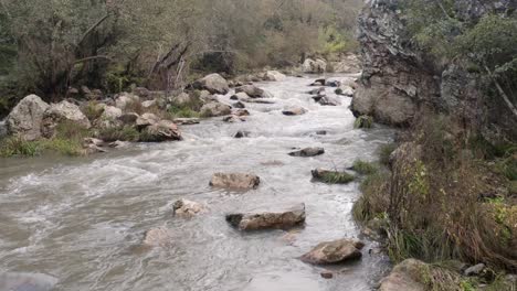 Water-Stream-Surrounded-And-Crashing-Over-Rocks-On-Peaceful-River-During-Daylight-Near-Oporto,-Portugal