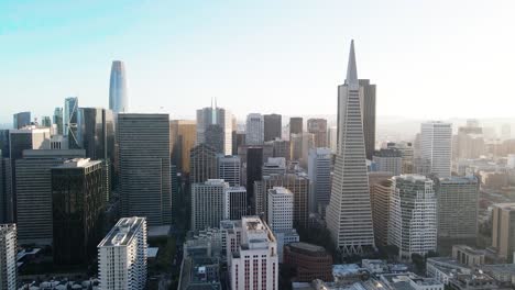 aerial view of a modern city skyline bathed in soft sunlight with skyscrapers and clear blue sky