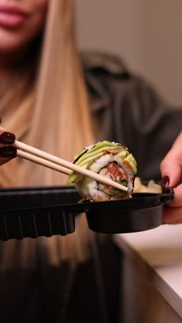 una mujer comiendo un rollo de sushi.
